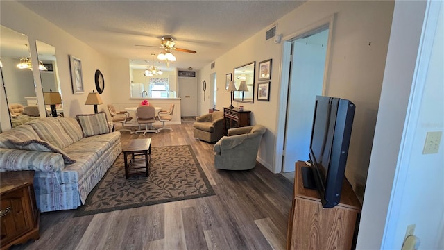 living room featuring ceiling fan, dark hardwood / wood-style flooring, and a textured ceiling