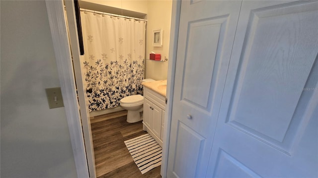 bathroom featuring hardwood / wood-style flooring, vanity, toilet, and a shower with shower curtain