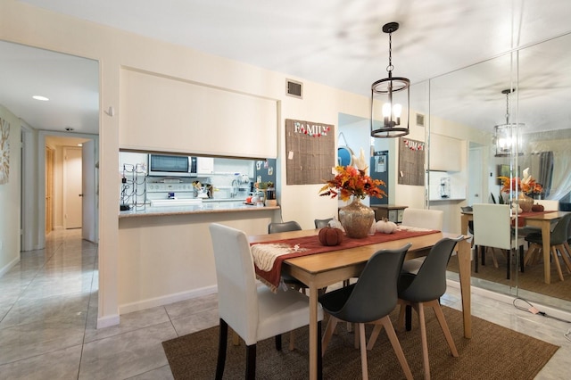 tiled dining area featuring an inviting chandelier