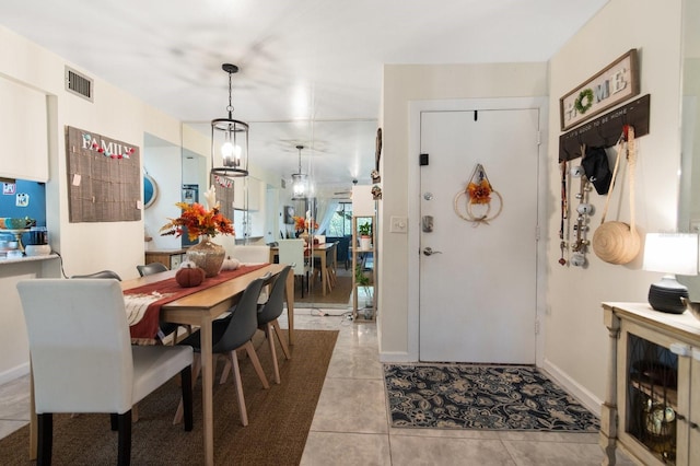 tiled dining area with a chandelier