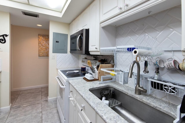 kitchen featuring light tile patterned flooring, white cabinets, backsplash, white electric range oven, and electric panel