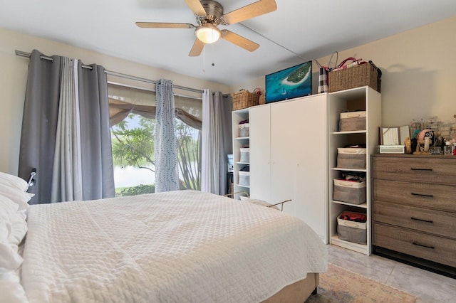 tiled bedroom featuring ceiling fan