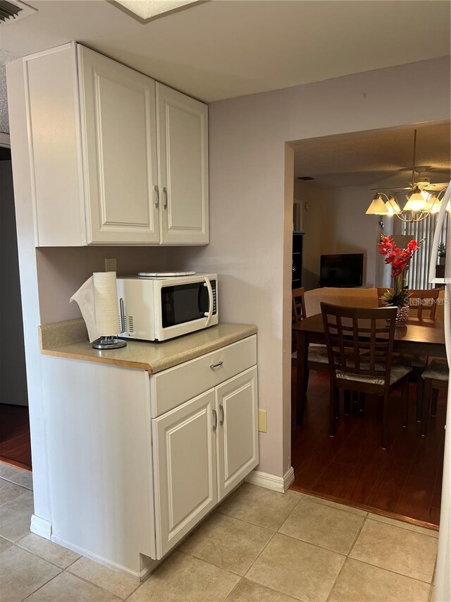 kitchen with hanging light fixtures, light hardwood / wood-style floors, and white cabinetry