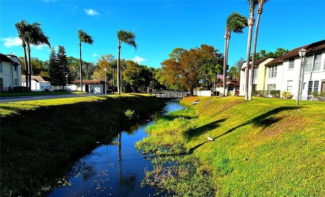 surrounding community with a lawn and a water view