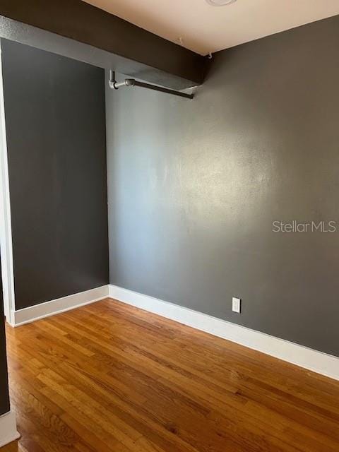 unfurnished room with wood-type flooring