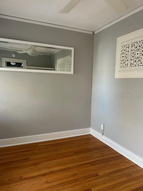 unfurnished room featuring hardwood / wood-style flooring and crown molding