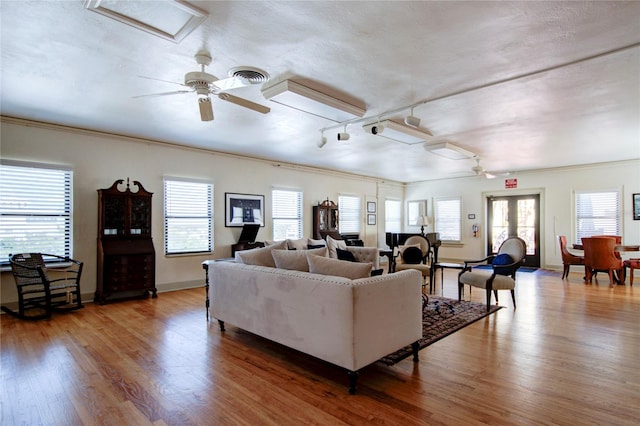 living room featuring track lighting, hardwood / wood-style flooring, ceiling fan, and plenty of natural light