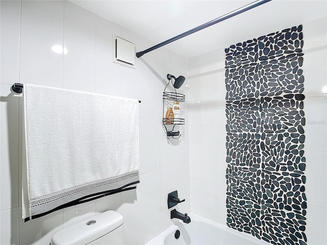 bathroom featuring tiled shower / bath and toilet