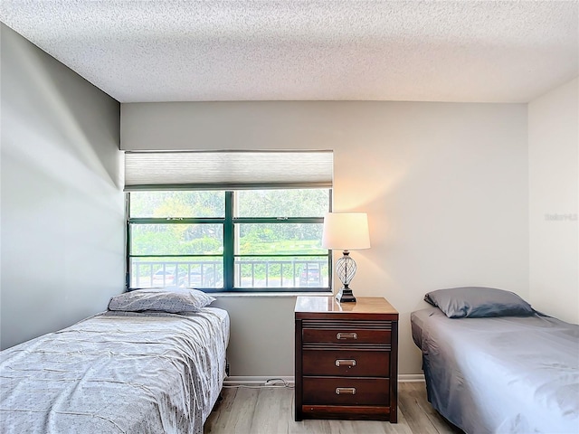 bedroom with a textured ceiling and light wood-type flooring