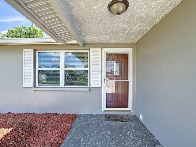 doorway to property featuring stucco siding