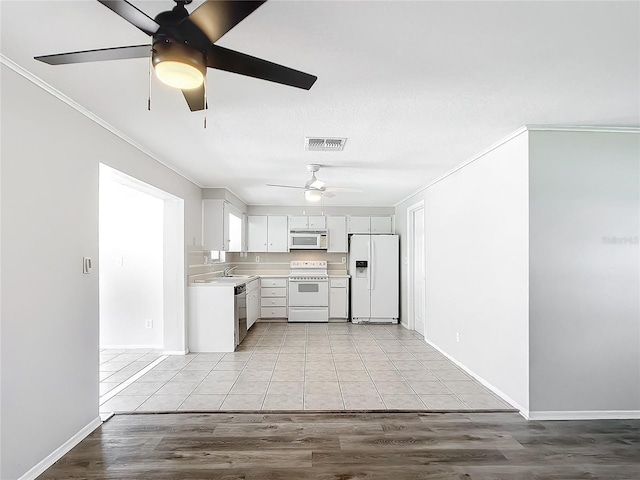 kitchen with sink, light hardwood / wood-style flooring, crown molding, white appliances, and white cabinets