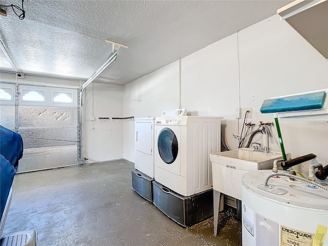 laundry area featuring a textured ceiling, washer and clothes dryer, and water heater