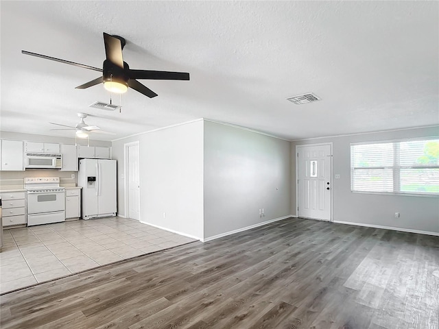 unfurnished living room featuring ceiling fan, a textured ceiling, and light hardwood / wood-style flooring