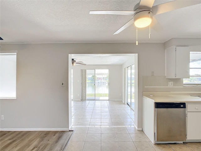 kitchen featuring dishwasher, white cabinetry, a textured ceiling, and a wealth of natural light