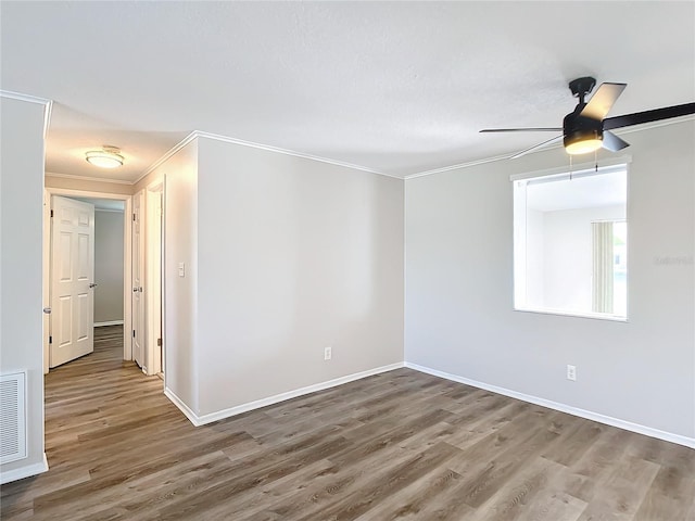 empty room featuring wood-type flooring, ceiling fan, and ornamental molding