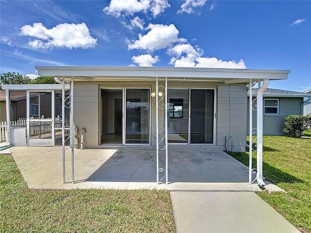 rear view of house with a lawn and a patio