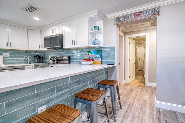 kitchen with visible vents, decorative backsplash, appliances with stainless steel finishes, white cabinets, and open shelves