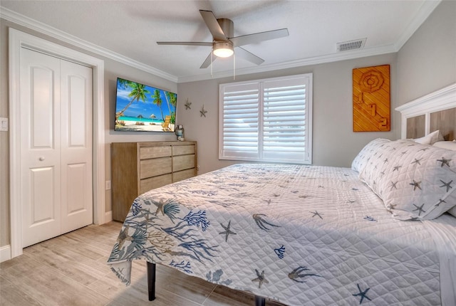 bedroom with light wood-type flooring, visible vents, ornamental molding, a closet, and ceiling fan