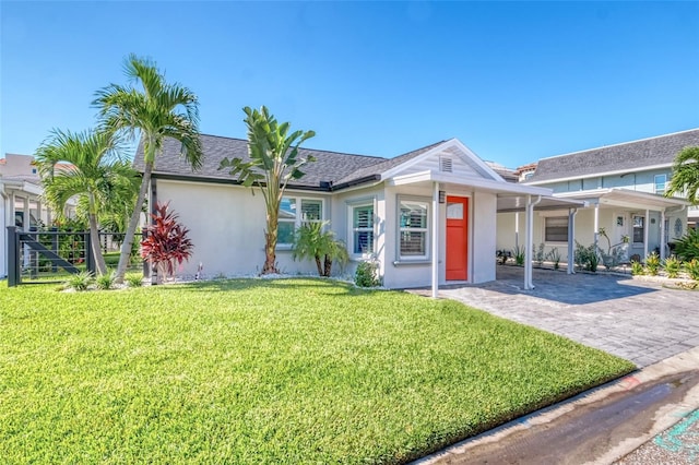 single story home with stucco siding, driveway, roof with shingles, and a front lawn