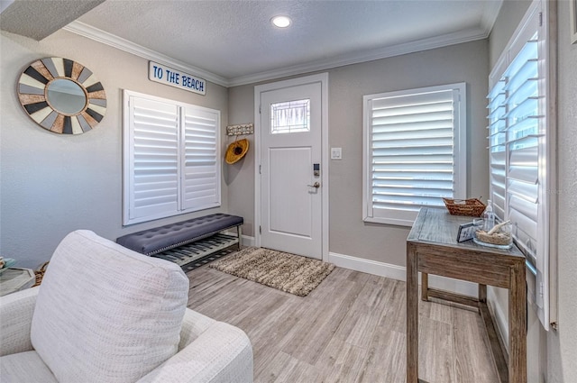 entrance foyer with baseboards, a textured ceiling, wood finished floors, and crown molding