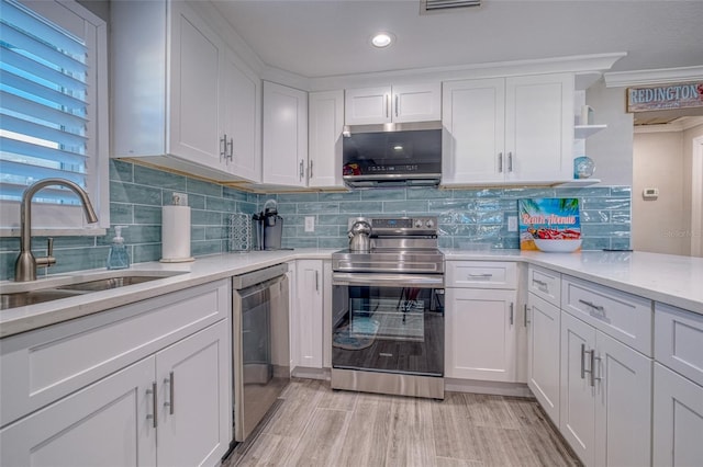 kitchen with open shelves, a sink, decorative backsplash, stainless steel appliances, and white cabinetry