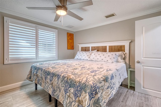 bedroom with visible vents, wood finished floors, and ornamental molding