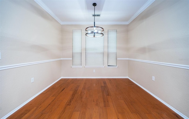 unfurnished dining area with ornamental molding, hardwood / wood-style floors, and a chandelier