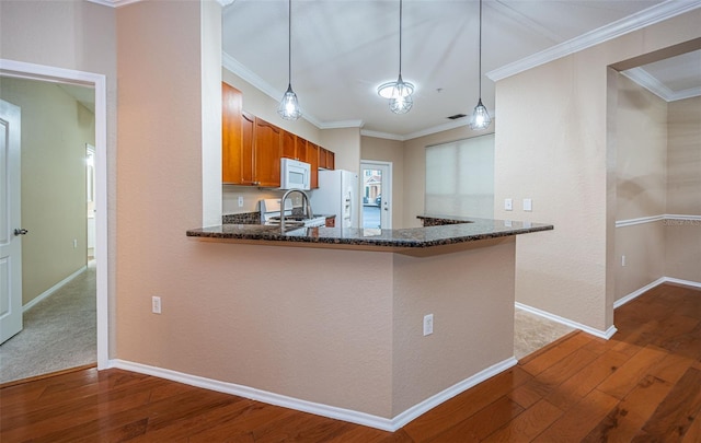 kitchen with hardwood / wood-style floors, crown molding, kitchen peninsula, and pendant lighting