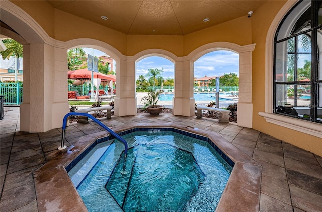 view of swimming pool featuring a patio and a community hot tub