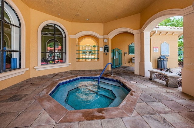 view of swimming pool with a patio area and an indoor hot tub