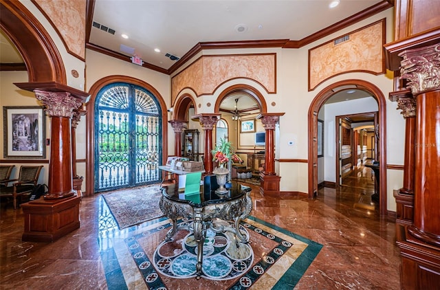 interior space featuring french doors, ornate columns, crown molding, and a high ceiling