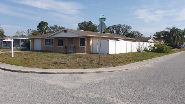 single story home featuring a garage and a front lawn