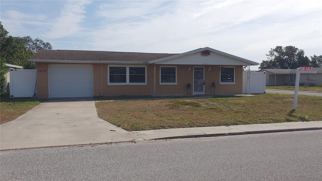 single story home featuring a front lawn and a garage