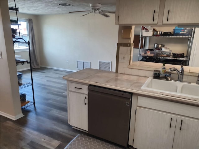 kitchen featuring black dishwasher, sink, dark hardwood / wood-style flooring, tile counters, and ceiling fan