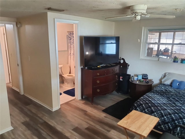 bedroom featuring hardwood / wood-style flooring, ceiling fan, connected bathroom, and a textured ceiling