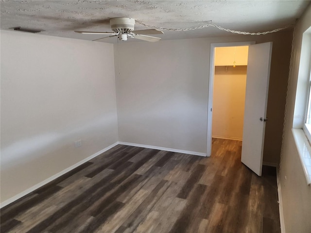 spare room with ceiling fan, dark hardwood / wood-style flooring, and a textured ceiling