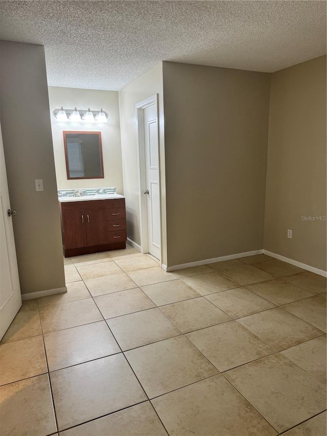 bathroom with vanity, a textured ceiling, and tile patterned floors