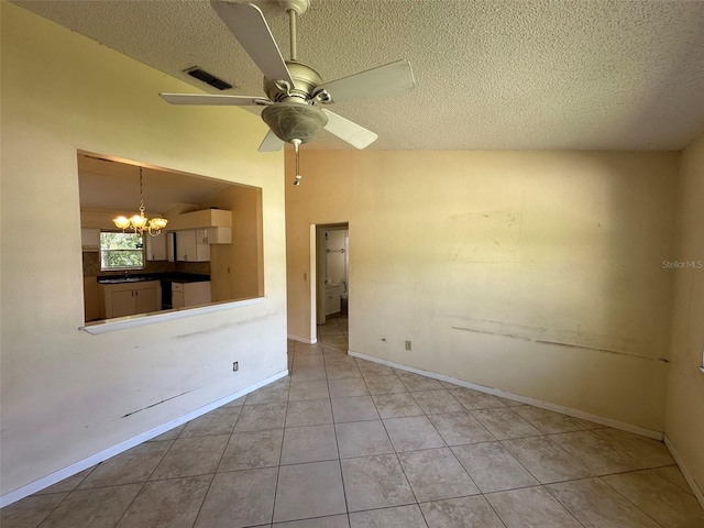 tiled empty room featuring ceiling fan with notable chandelier, sink, and a textured ceiling