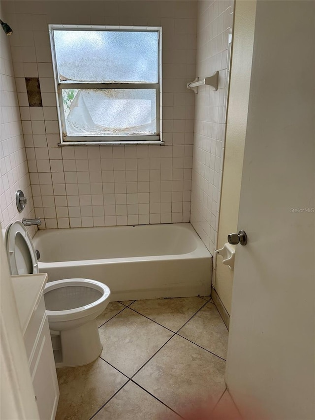 full bathroom with tiled shower / bath, toilet, vanity, and tile patterned floors