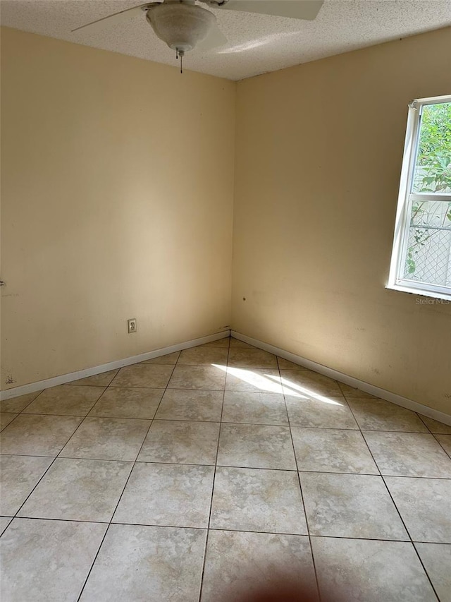 unfurnished room with light tile patterned floors and ceiling fan