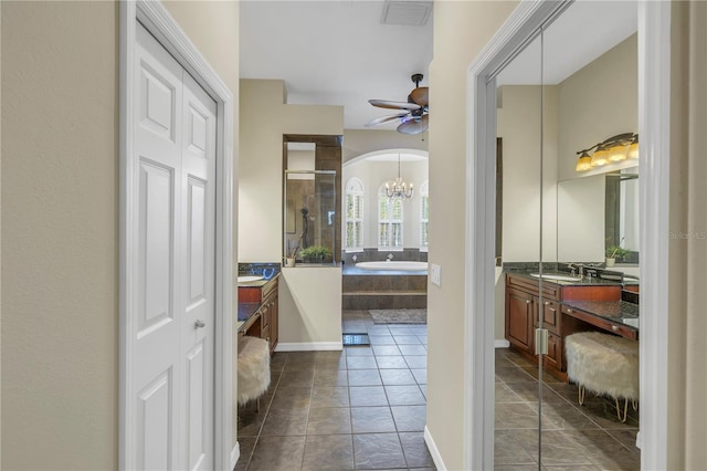 bathroom with tile patterned flooring, ceiling fan with notable chandelier, separate shower and tub, and vanity