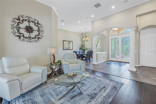 living room featuring ornamental molding, french doors, wood-type flooring, and decorative columns