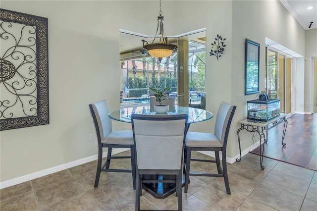 dining room featuring crown molding, wood-type flooring, and a healthy amount of sunlight