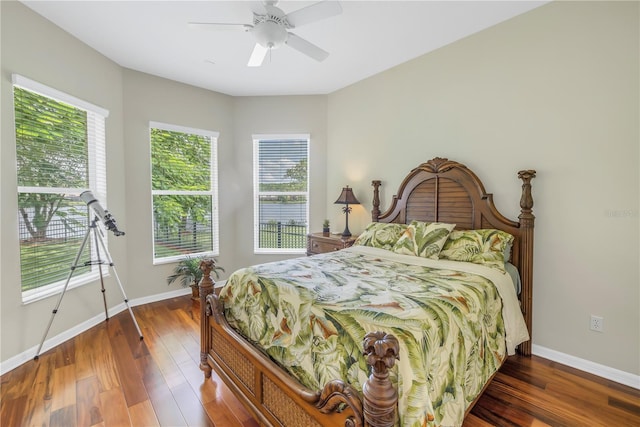 bedroom with dark wood-type flooring, ceiling fan, and multiple windows