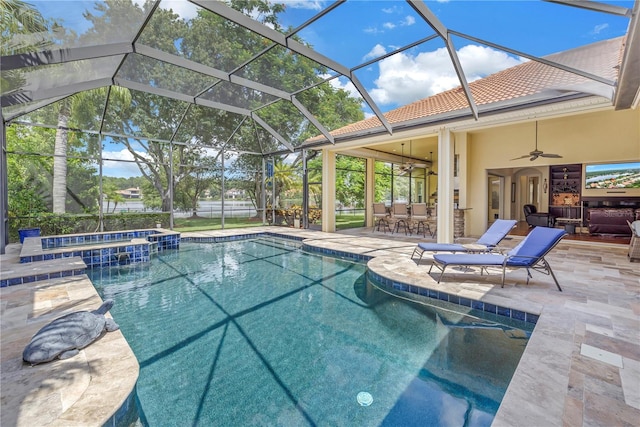 view of swimming pool with glass enclosure, an in ground hot tub, ceiling fan, and a patio