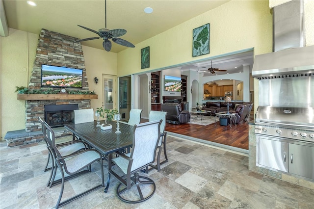 view of patio / terrace featuring a fireplace, an outdoor kitchen, and ceiling fan