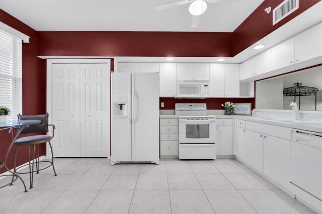 kitchen with a healthy amount of sunlight, ceiling fan, white appliances, and white cabinets