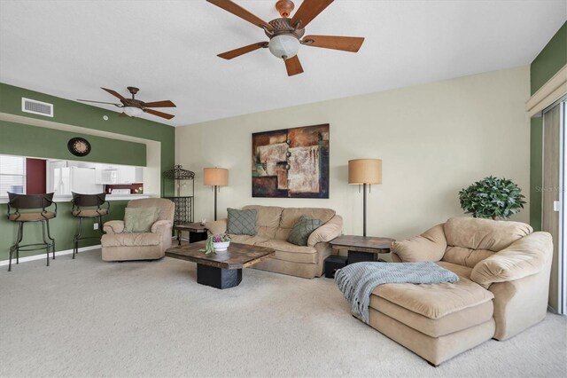 carpeted living room with ceiling fan