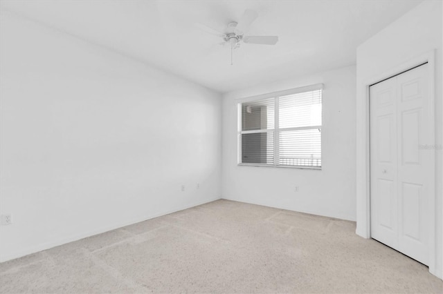 unfurnished bedroom with light carpet, ceiling fan, and a closet