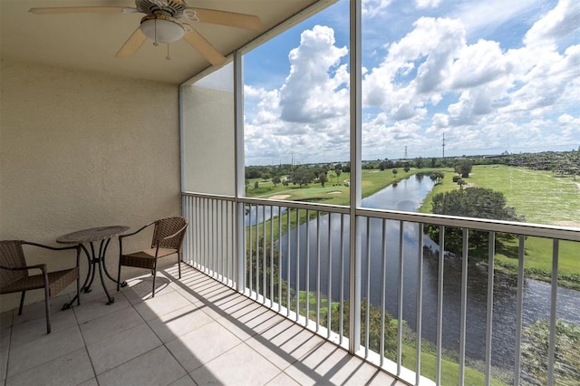 balcony featuring a water view and ceiling fan